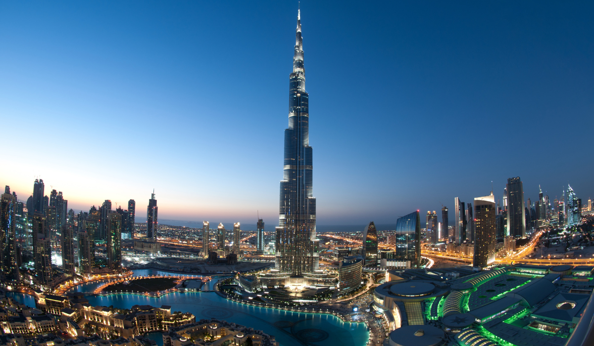 Tourists visiting Dubai Frame, golden landmark with city view in background.