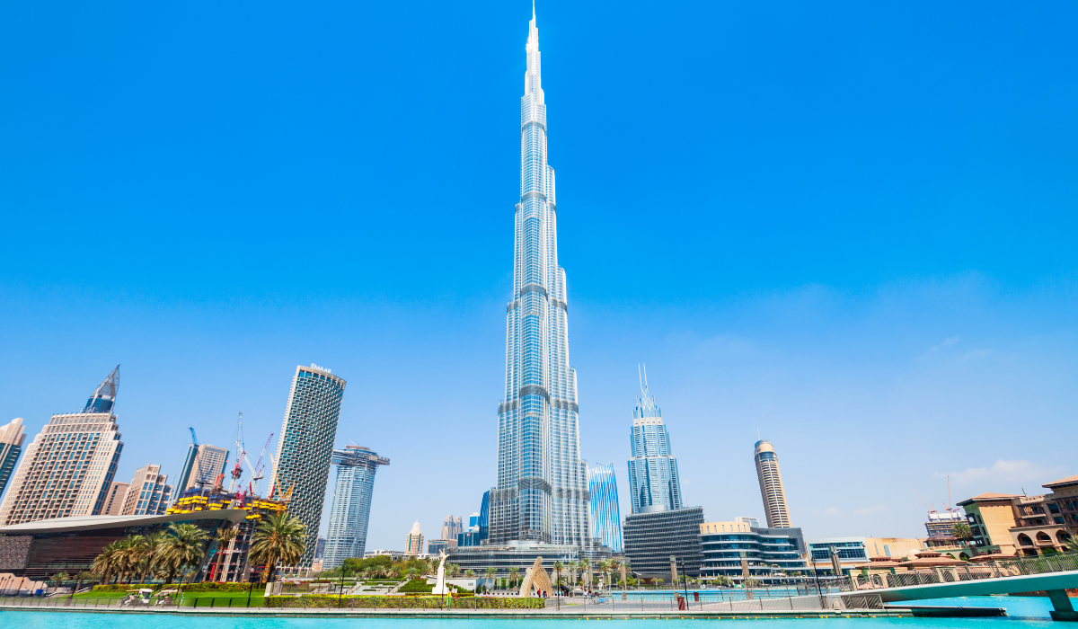 Tourists shopping inside Dubai Mall with luxury stores and vibrant lights.