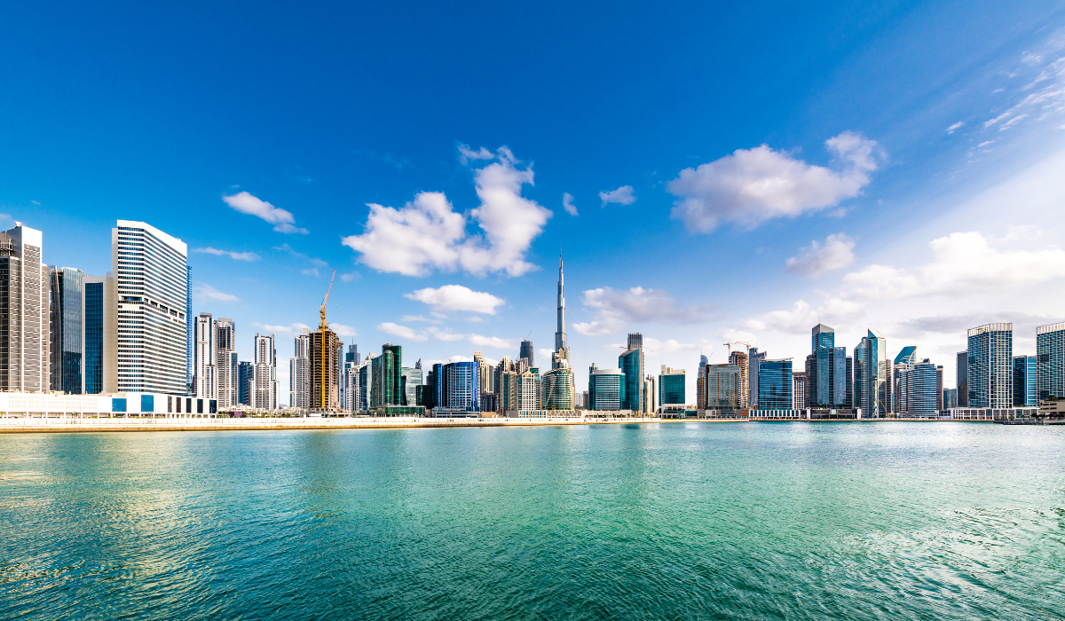 Dubai Marina waterfront view with luxury yachts and high-rise towers at night.