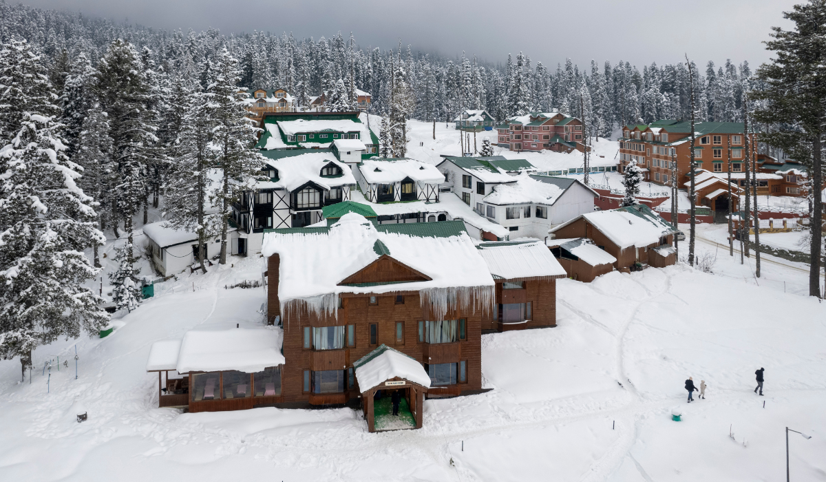 Shikara boat floating on Dal Lake Srinagar with mountains in background.